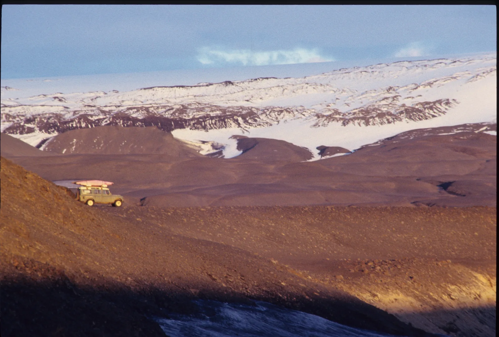 A Land Rover dwarfed by the snow-streaked highlands near Vatnajökull, 1989